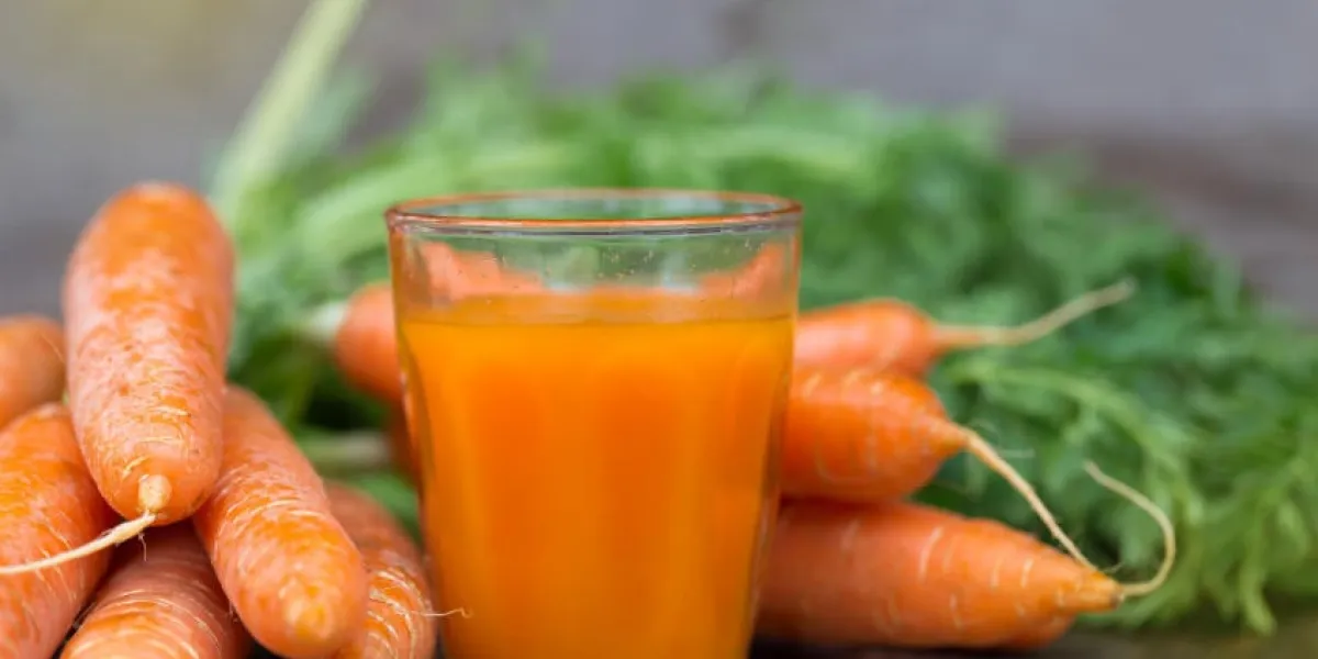 jus de carotte frais sur un fond en bois