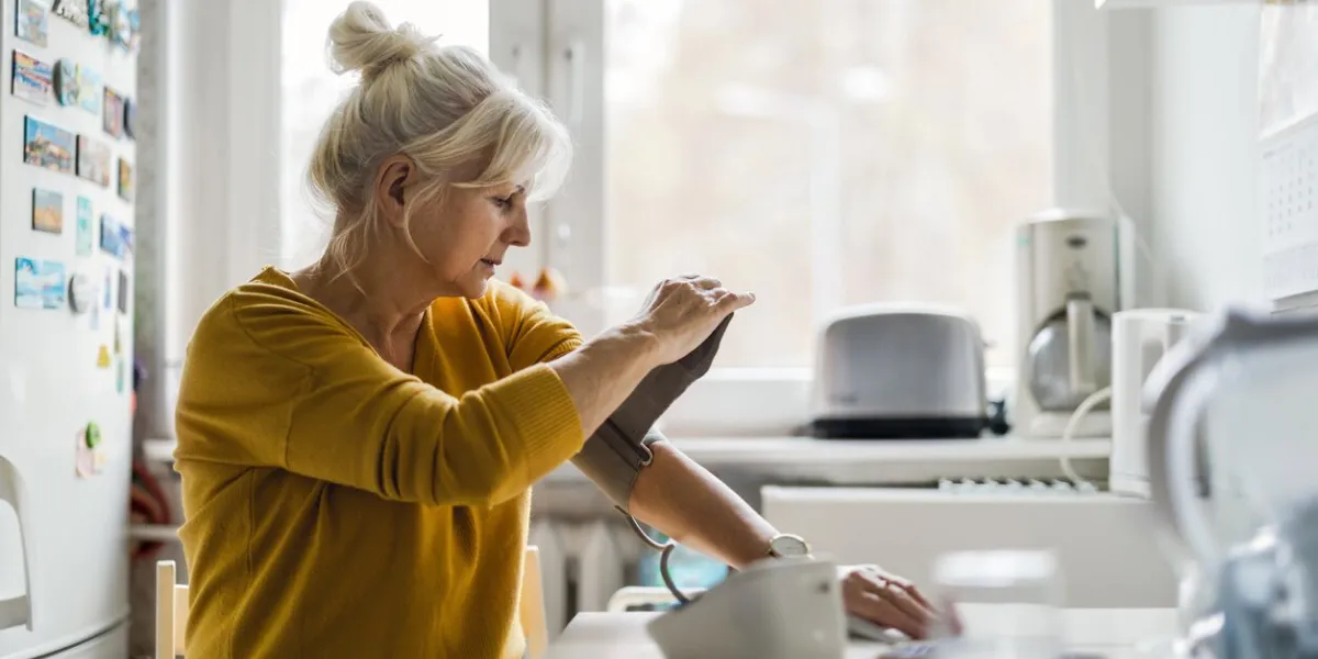 senior woman measuring blood pressure at home