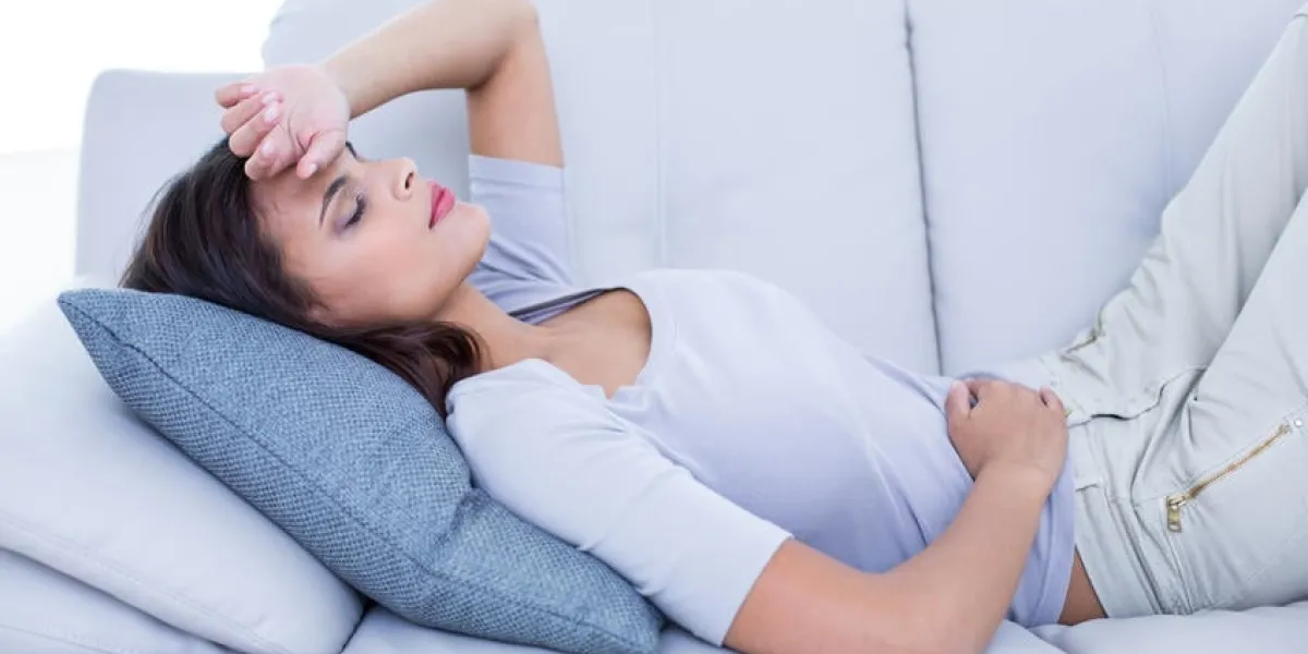 brunette malade allongé sur le canapé dans le salon