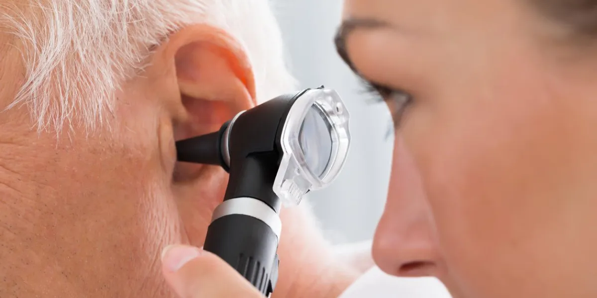 close-up of female doctor examining patient's ear with otoscope