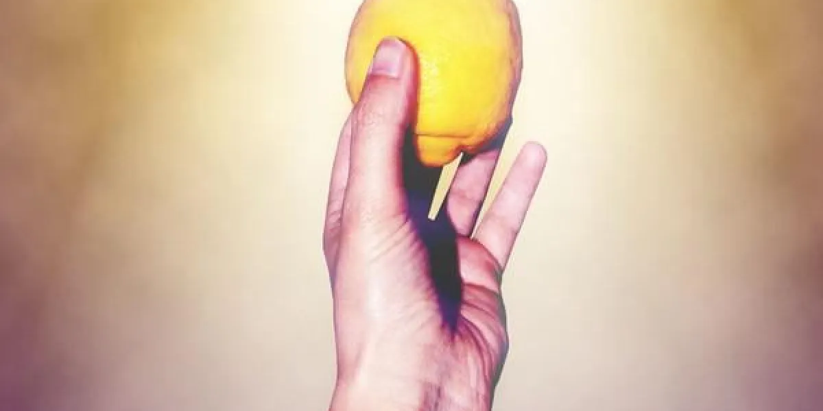 bras levé avec du citron dans sa main sur un fond violet