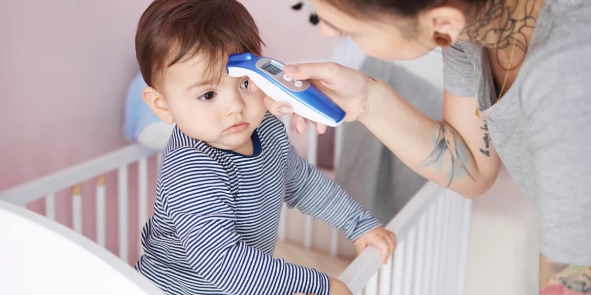 mother with digital thermometer checking temperature