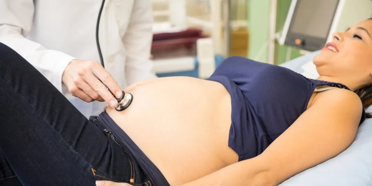 gros plan, mâle, docteur, utilisation, stéthoscope, examiner, enceinte, femme, hôpital