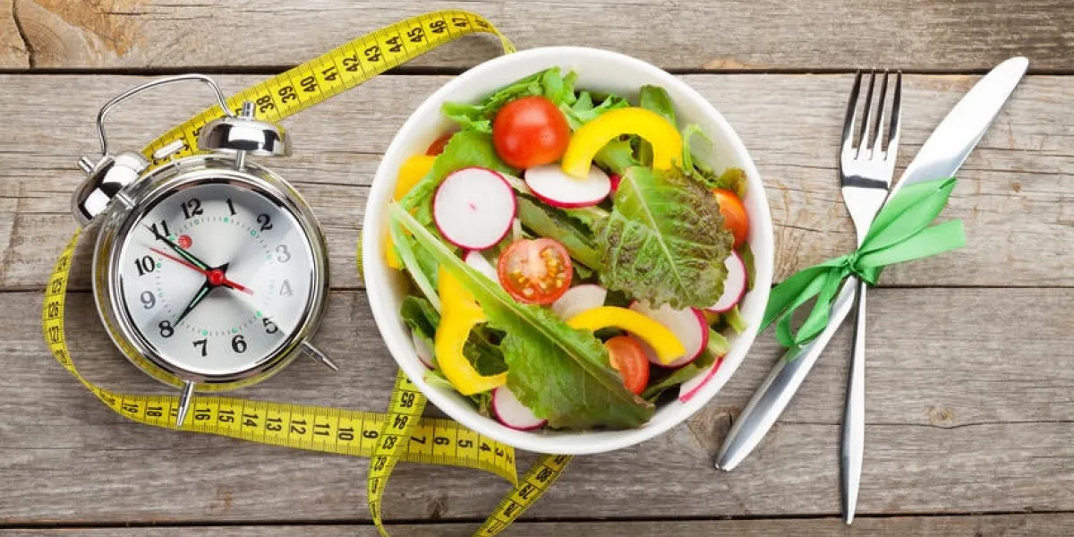 salade fraîche et ruban à mesurer sur la table en bois