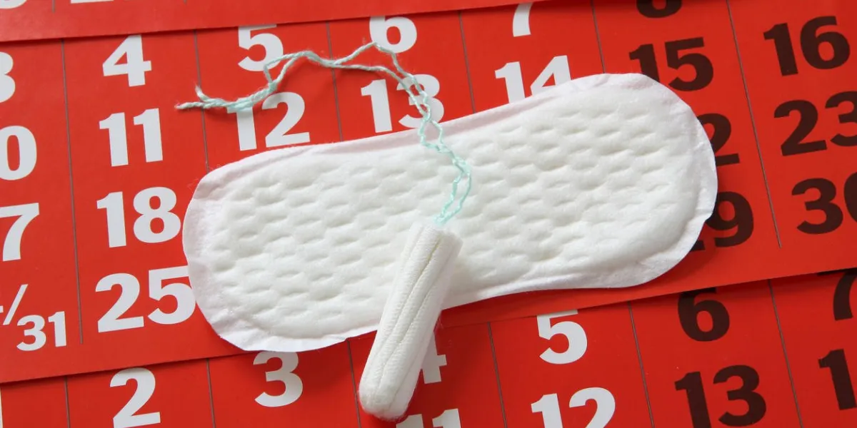 la serviette hygiénique allongée sur un calendrier rouge