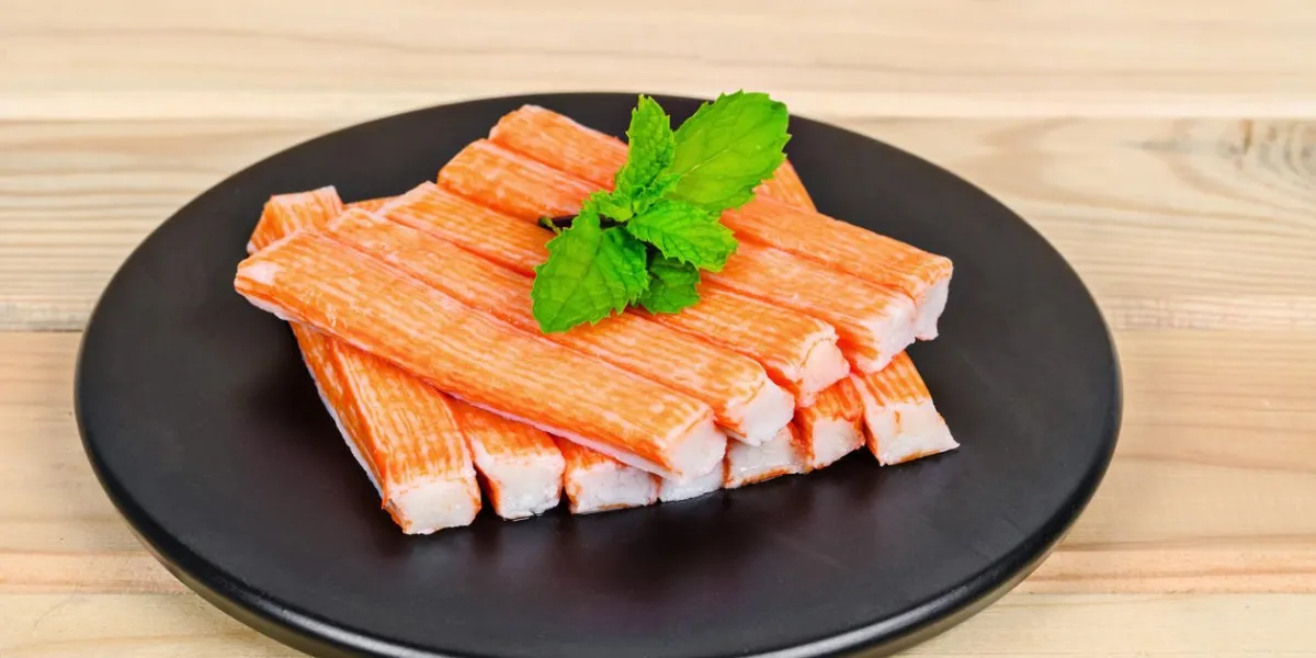bâtonnet de crabe dans un plat noir sur fond en bois