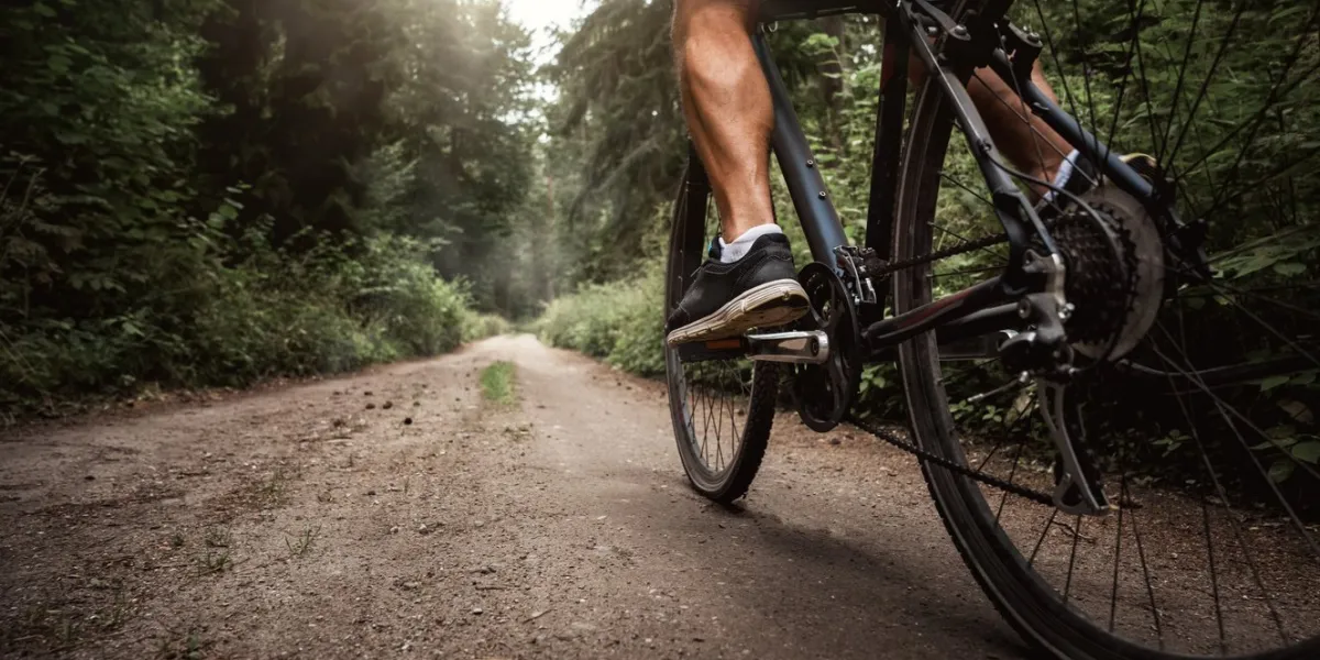 close up of a biker riding a bike through the forest road