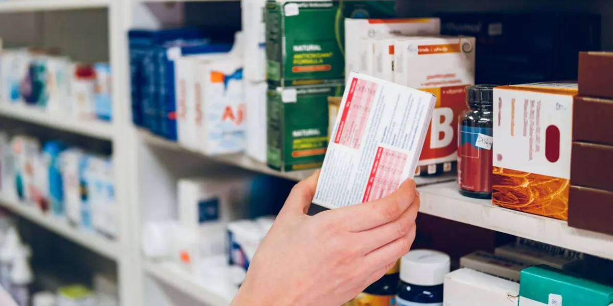 a young female pharmacist arranges medicines on the shelves of the pharmacy and makes an inventory
