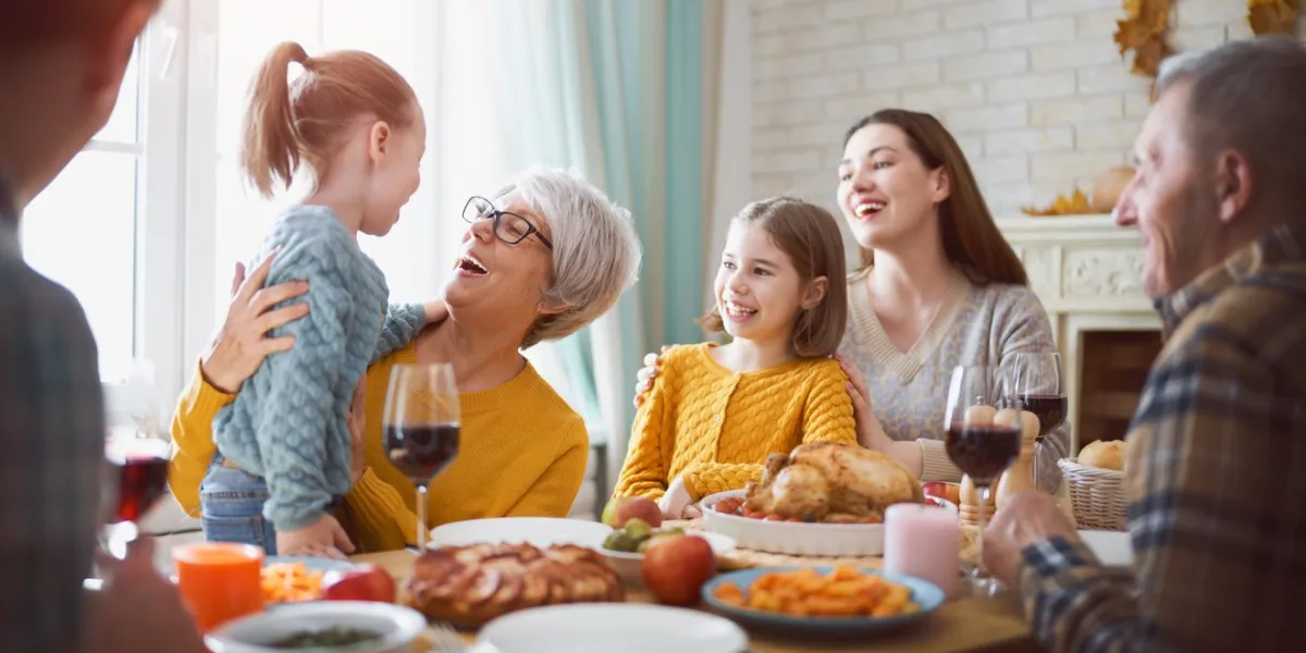happy thanksgiving day autumn feast family sitting at the table and celebrating holiday grandparents, mother, father and children traditional dinner