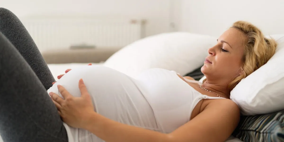 pregnantwoman lying ill in bed with contractions
