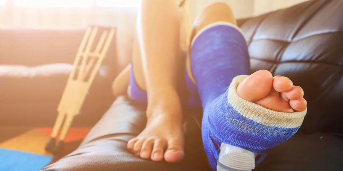 broken leg in a plaster cast with soft-focus in the background over light