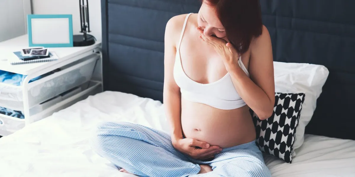 problems or symptoms of poor health during pregnancy pregnant woman suffering with nausea at home interiors pregnancy, parenthood, preparation and expectation concept