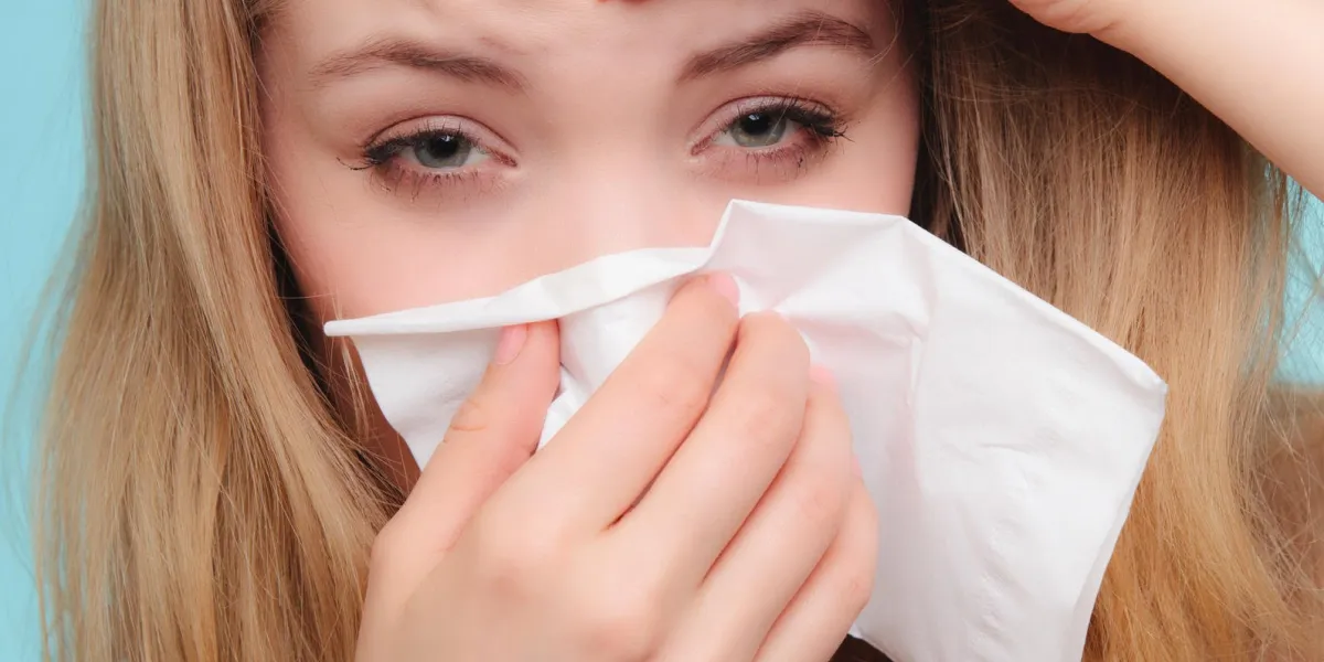 grippe rhume ou un symptôme d'allergie malade femme fille avec de la fièvre éternuement dans les tissus sur les soins de santé bleu