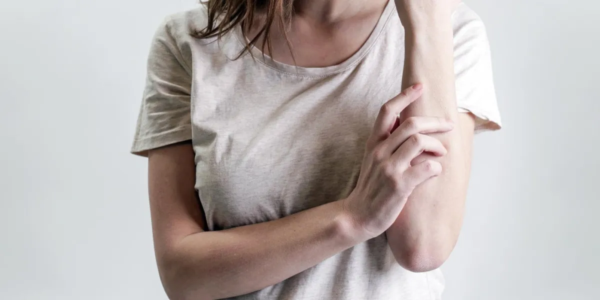 close up view of woman scratching her arm health care and medical concept