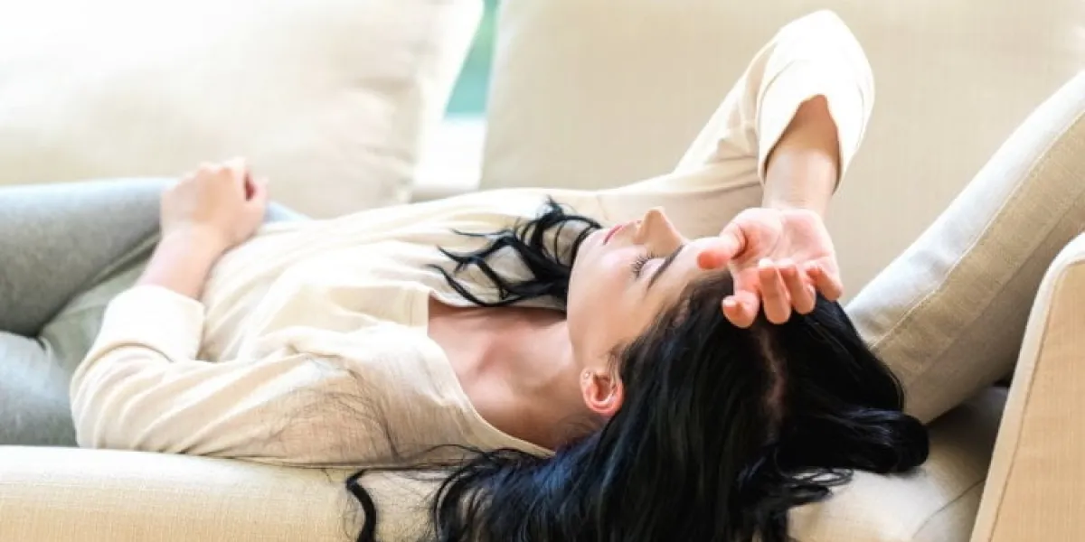 sick young woman with a fever or illness in a bright interior room