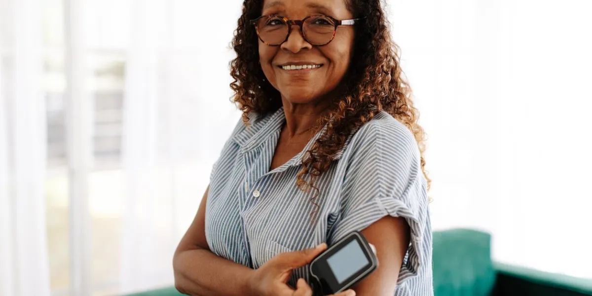 portrait of a woman using continuous glucose monitoring to manage her diabetes at home mature woman using the latest health technology to measure and keep her blood glucose levels under control