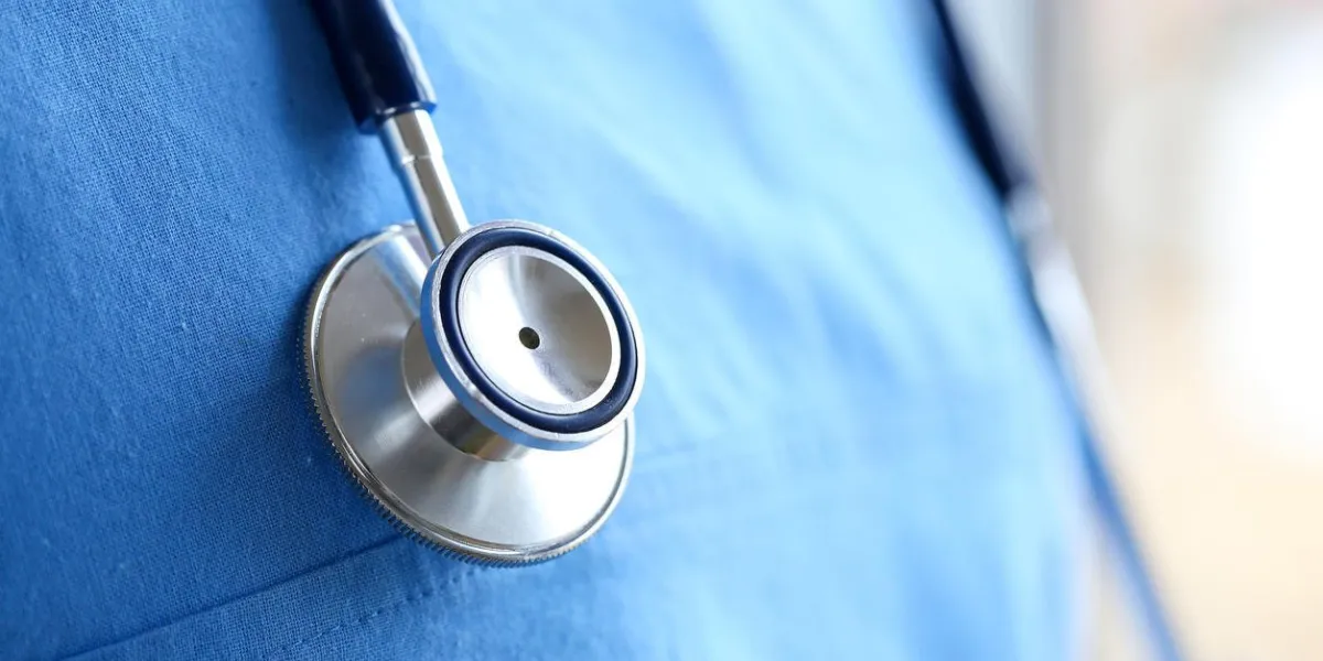 tête de stéthoscope couché sur la médecine therapeutist médecin poitrine portant uniforme bleu closeup soins médicaux, aide ou assurance, magasin de matériel ou magasin concept médecin attendant que le patient examine