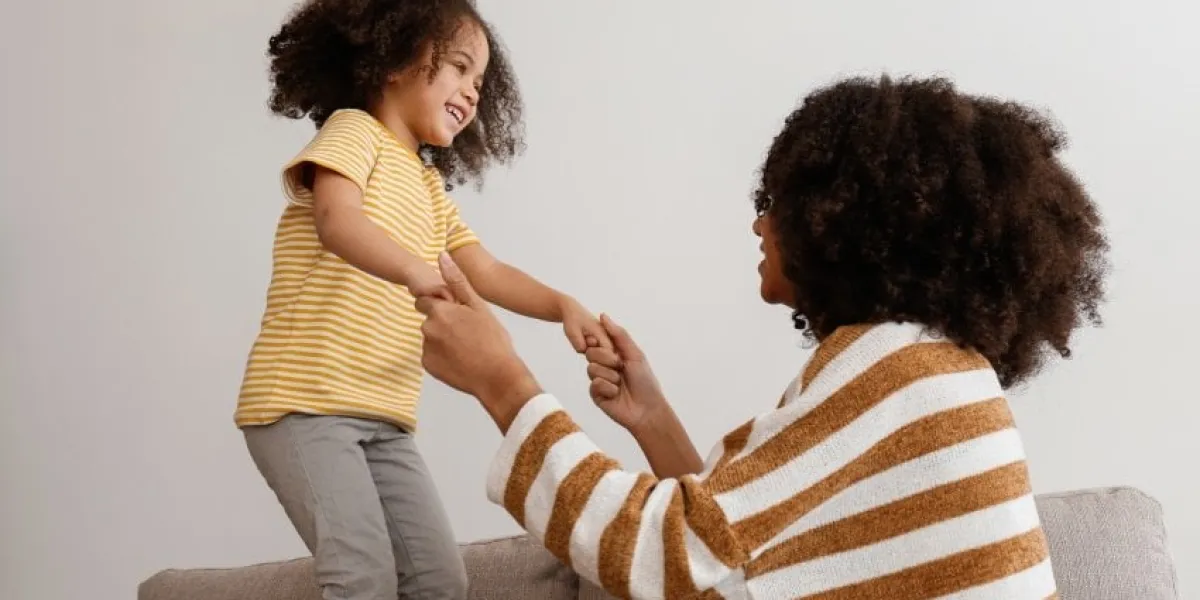 younger and older sister spending time together at home two black girls of different age messing around and playing black female siblings having fun and bonding background, copy space, close up