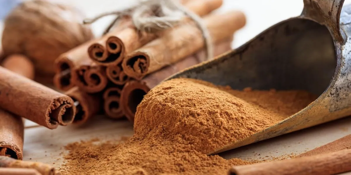 bâtons de cannelle et de la poudre sur une surface en bois