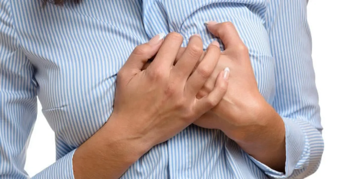 femme serrant sa poitrine dans la douleur comme elle souffre des symptômes préliminaires d'une crise cardiaque ou d'un infarctus du myocarde, bouchent la vue du corps isolé sur blanc