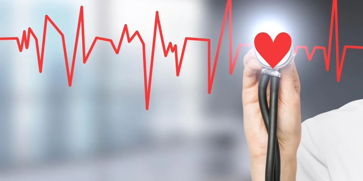 main écoutant un coeur rouge avec un phonendoscope, le coeur fait partie d'un cardiogramme concept de fond de bureau flou d'examen médical