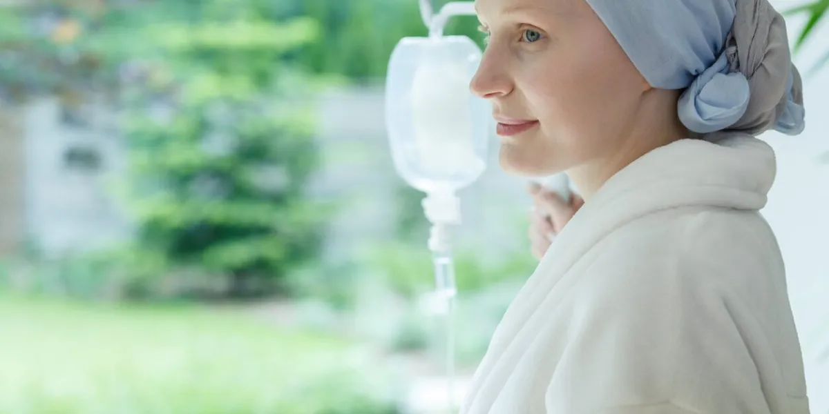 woman in white robe smiling and looking out the window