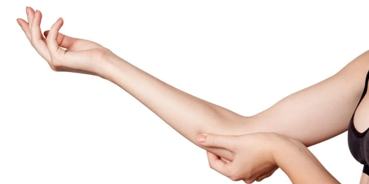 closeup view of a young woman with elbow pain isolated on white background