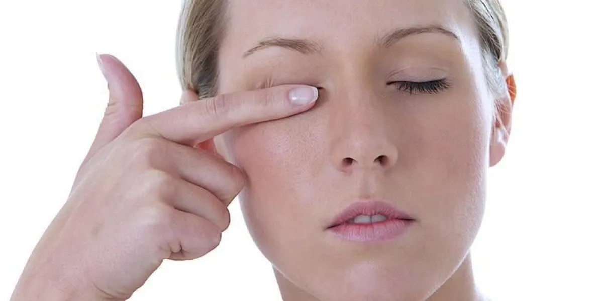 femme se frotte l'oeil