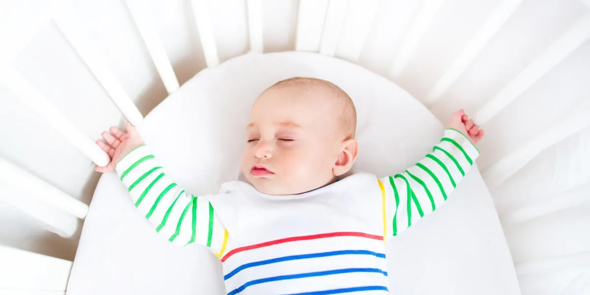 mignon petit garçon nouveau-né dort dans un berceau rond blanc