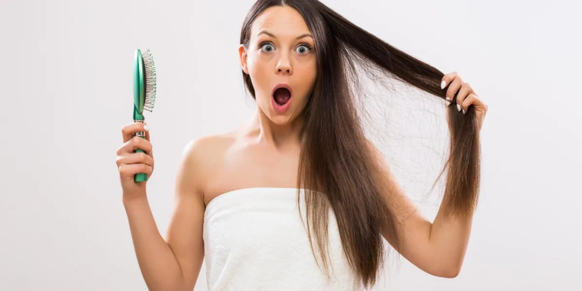 beautiful woman in panic because of hair loss looking at camera