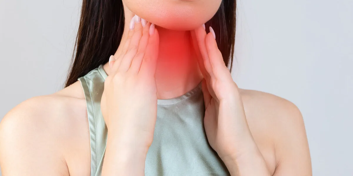 sore throat in flu season young asian woman touching her neck and feeling pain in throat in the bedroom at home