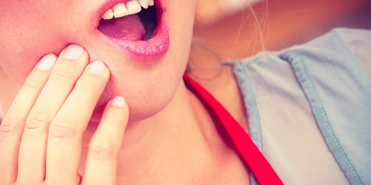 closeup of woman female suffering from toothache tooth pain