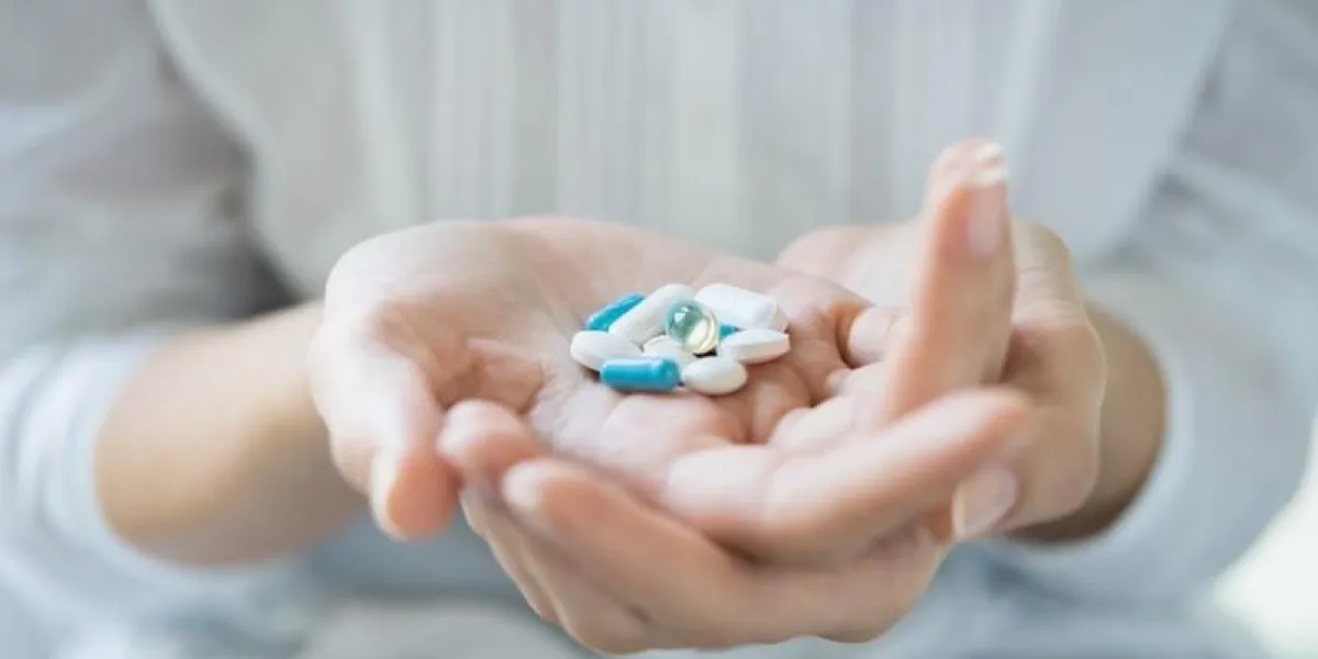 closeup, coup, de, a, femme, tenue, divers, pilules, main, girl, à, chemise blanche, projection, médecines, et, pilules, intérieur, peu profond, profondeur, de, champ, à, foyer, sur, pilule