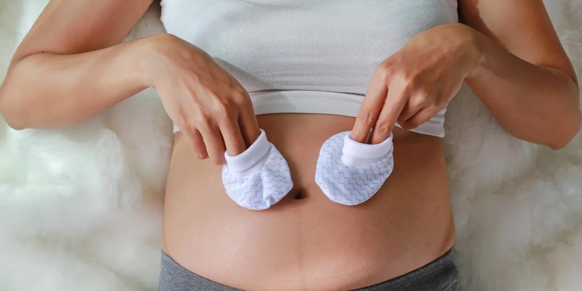 pregnant woman put a little socks on tummy