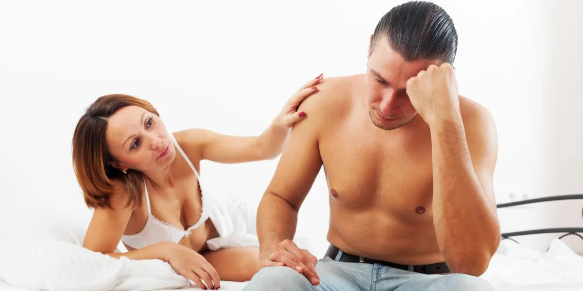 l'homme d'âge moyen a un problème, la femme le réconfortant au lit