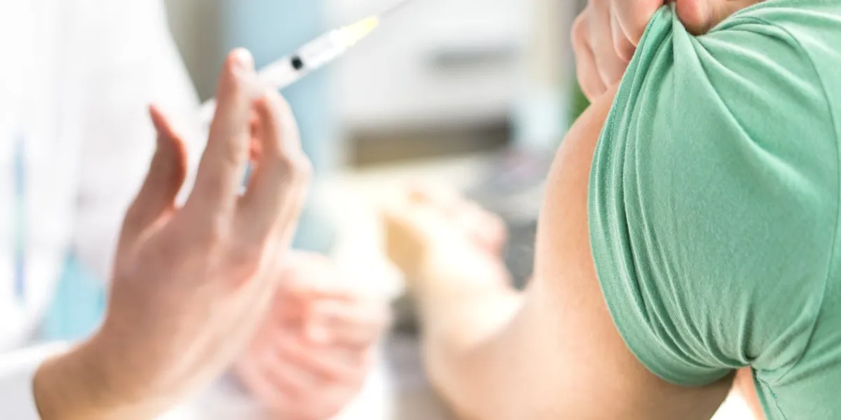 doctor giving patient vaccine, flu or influenza shot or taking blood test with needle nurse with injection or syringe medicine, insulin or vaccination hospital office room