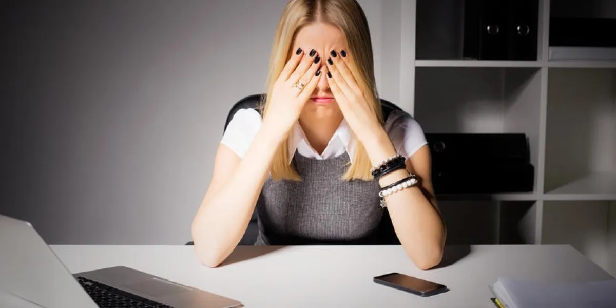 femme assise dans son bureau avec les yeux couverts