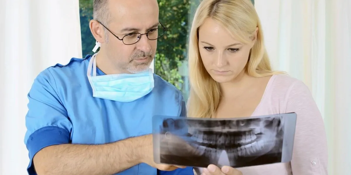 zahnarzt bespricht röntgenbild mit patientin
