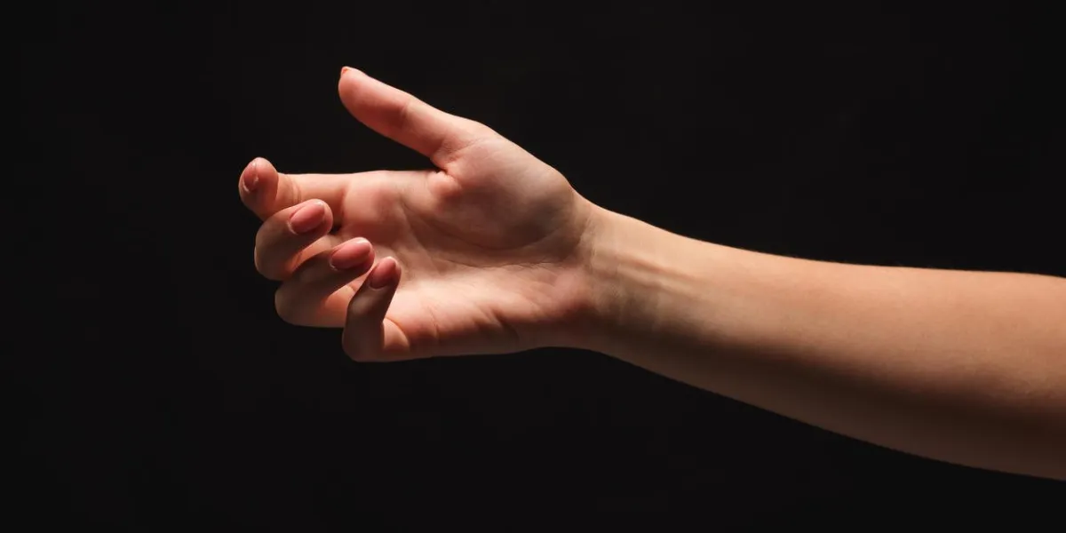 tender female helping hand on black background, isolated woman stretching hand to show or ask for support and care, copy space, cutout