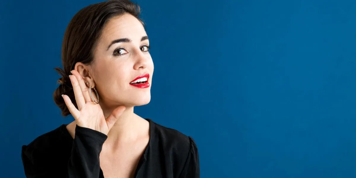 young woman listening on a blue background