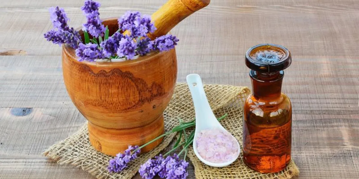 huile essentielle de lavande, mortier en bois avec des fleurs de lavande fraîche, sels de bain sur fond en bois