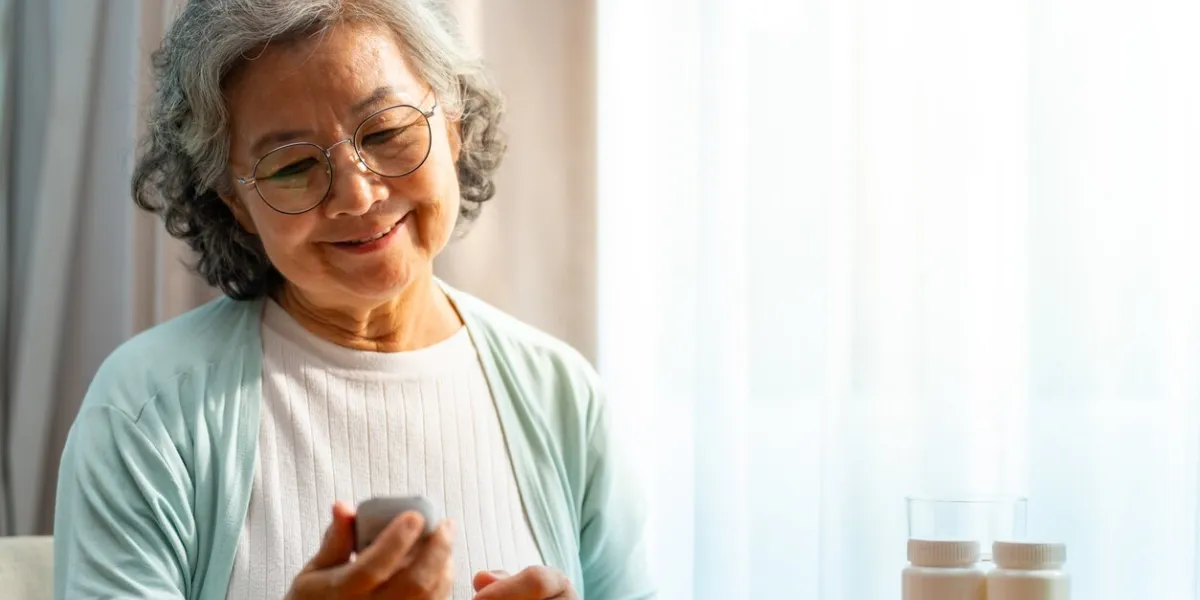 asian senior mature woman patient with diabetes using medical device glucometer checking glucose in blood by herself in bedroom at home elderly people self-care and daily health check concept