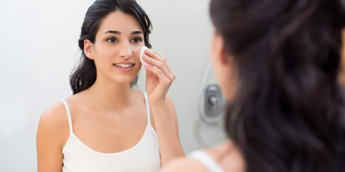 fille douce en bonne santé enlevant maquillage de son visage avec une serviette en coton fille souriante nettoyage son visage en salle de bain belle femme en bonne santé faisant un gommage sur son visage