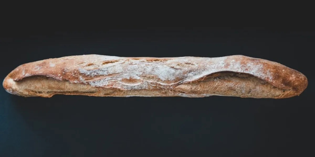 baguette de pain françaiseil s'agit d'une baguette tradition achetée dans une boulangerie traditionnellela photo a été prise sur fond noirla lumière est naturelle