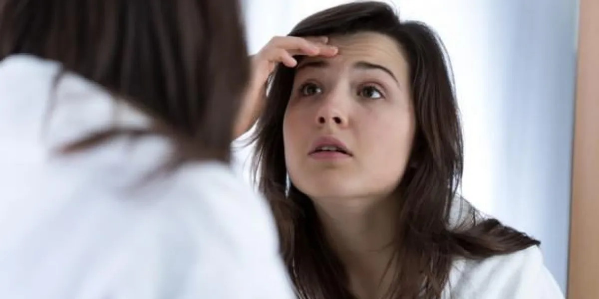 fille ayant des problèmes avec la peau à la recherche dans le miroir