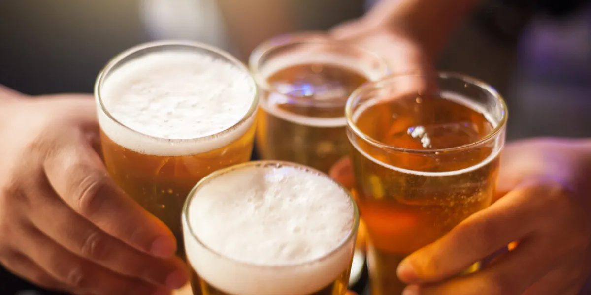 cheers clink glasses close-up shots of hands holding beer glasses and beer bubbles