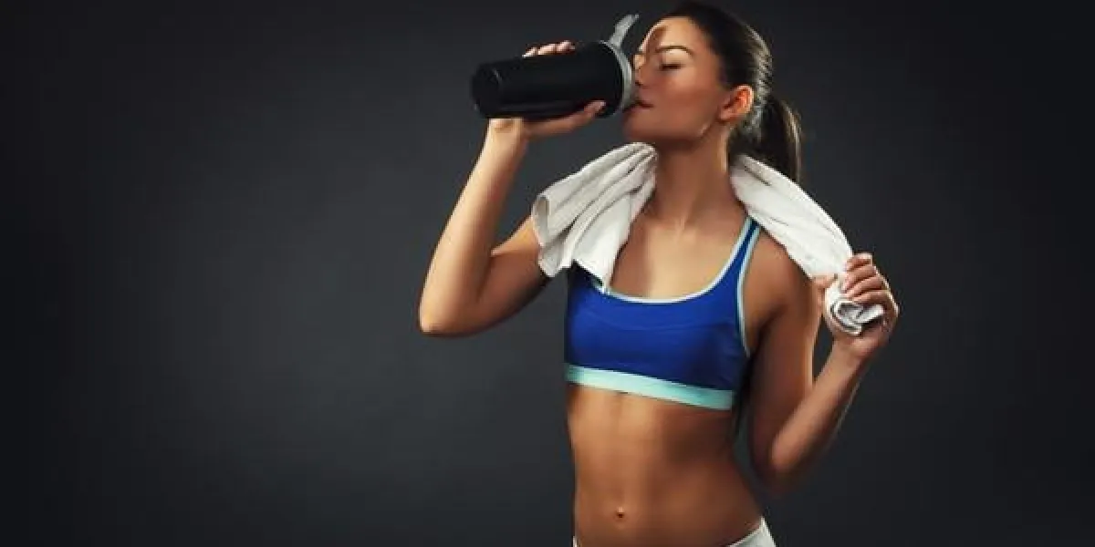 séduisante jeune femme buvant des protéines