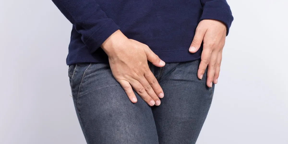 femme avec les mains tenant son entrejambe