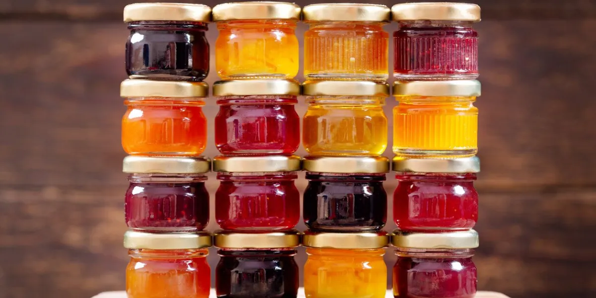 various jars of fruit jam on wooden table