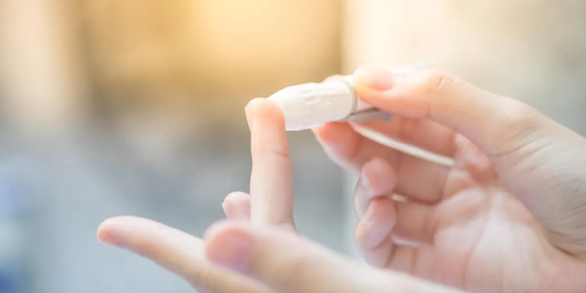 gros plan des mains de femme asiatique à l'aide de lancette sur le doigt pour vérifier le niveau de sucre dans le sang par le glucomètre, médical de santé et de vérifier, le diabète, la glycémie et le concept de personnes